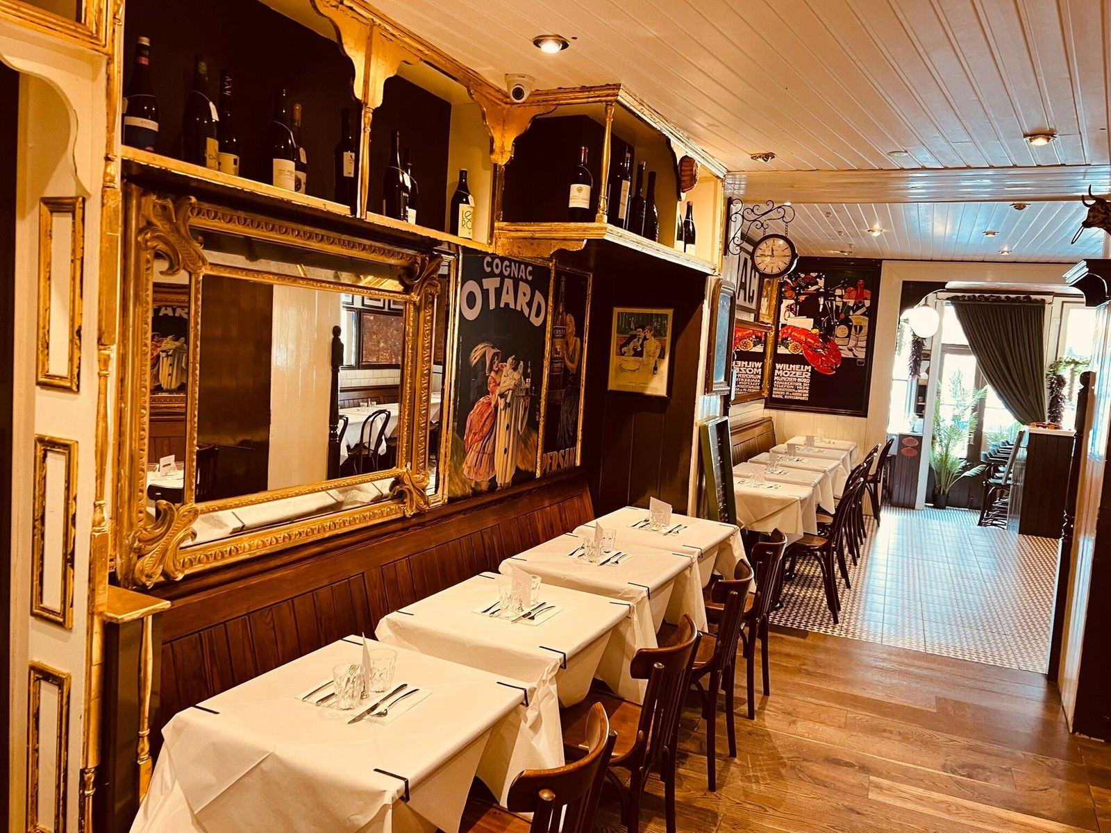 The bistro room, gilt mirrors and white linen.